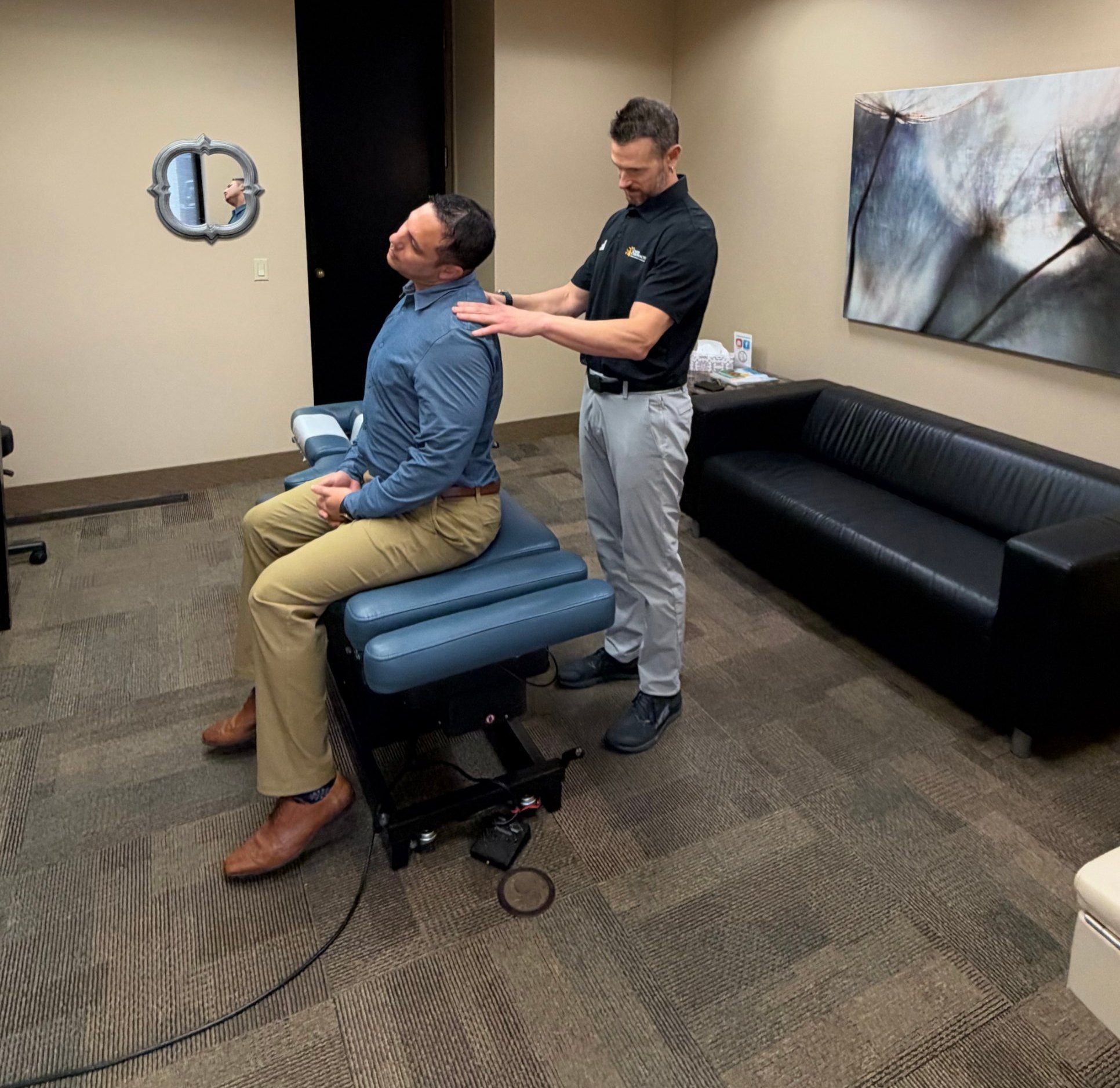 A chiropractor checking neck range of motion during an exam.